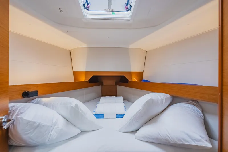 Minx Yacht Photos Pics 2024 Jeanneau Sun Odyssey 349 cabin interior with cozy bedding and natural light.
