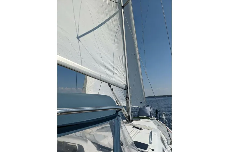 Dolce Vita Yacht Photos Pics Sailing on a 2004 Hunter 41 AC yacht with white sails against a clear blue sky.