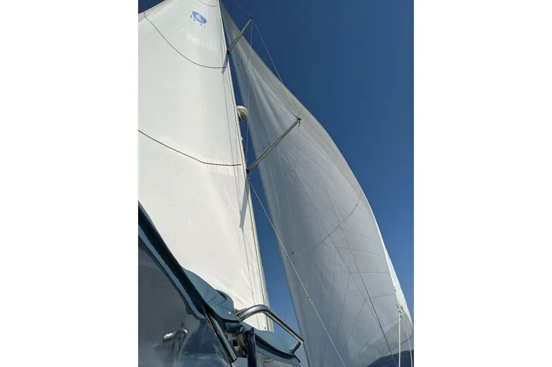 Dolce Vita Yacht Photos Pics Sails of a 2004 Hunter 41 AC yacht against a clear blue sky.