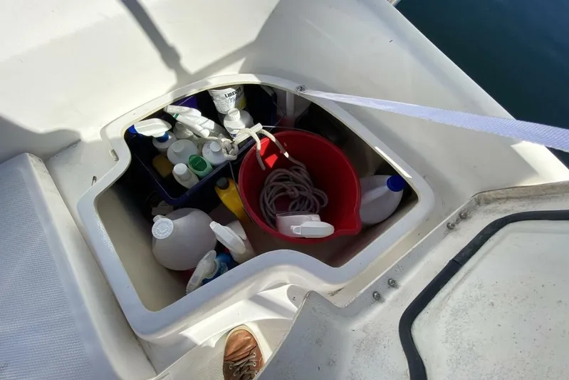 Dolce Vita Yacht Photos Pics Storage compartment on a 2004 Hunter 41 AC sailboat, containing cleaning supplies and a red bucket.