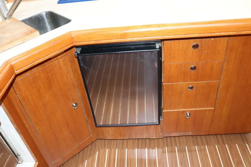 Dolce Vita Yacht Photos Pics Wooden kitchen cabinetry with fridge in 2004 Hunter 41 AC yacht interior.