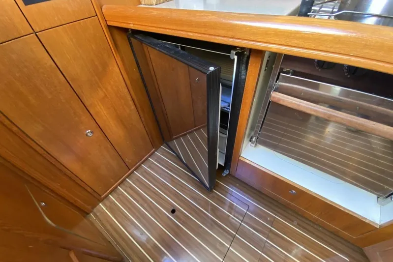 Dolce Vita Yacht Photos Pics 2004 Hunter 41 AC yacht interior with open fridge and wooden cabinetry.
