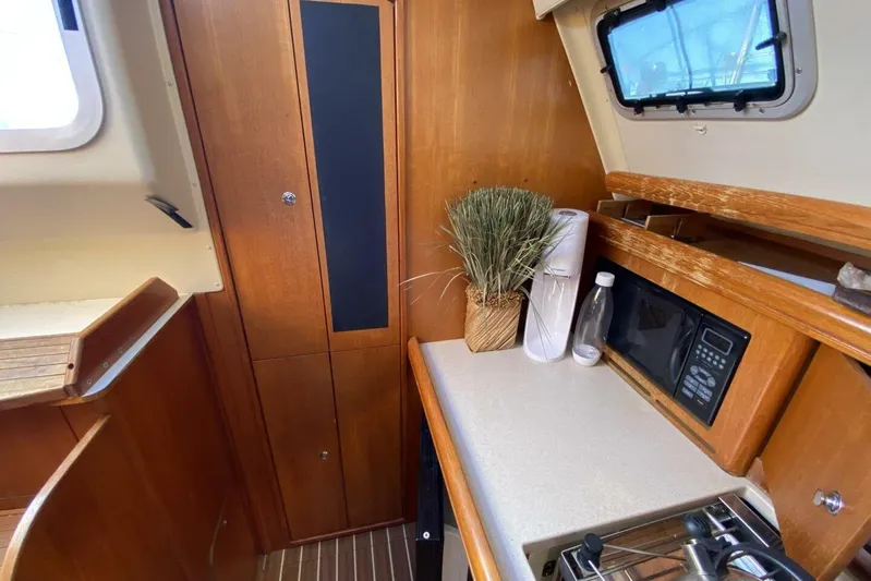 Dolce Vita Yacht Photos Pics Interior of 2004 Hunter 41 AC sailboat kitchen with wood cabinetry and appliances.