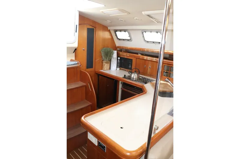 Dolce Vita Yacht Photos Pics Interior of 2004 Hunter 41 AC yacht with modern kitchen and wooden cabinetry.