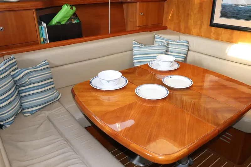 Dolce Vita Yacht Photos Pics 2004 Hunter 41 AC yacht interior with dining table, striped cushions, and elegant tableware.
