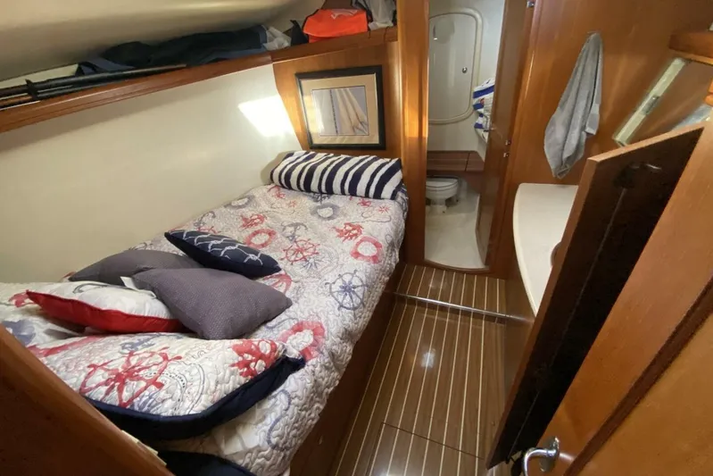 Dolce Vita Yacht Photos Pics Cozy cabin interior of 2004 Hunter 41 AC sailboat with nautical-themed bedding.
