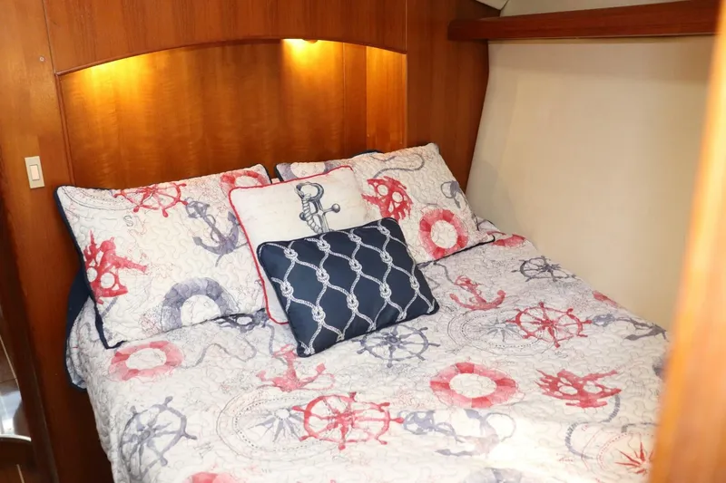 Dolce Vita Yacht Photos Pics Cozy cabin bedroom in 2004 Hunter 41 AC sailboat with nautical-themed bedding.