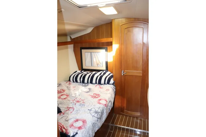 Dolce Vita Yacht Photos Pics Cozy cabin interior of 2004 Hunter 41 AC sailboat with nautical-themed bedding.