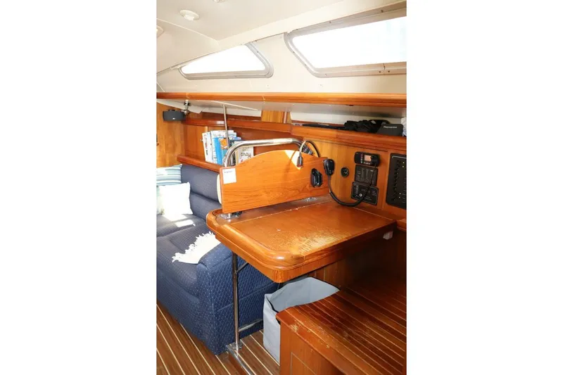 Dolce Vita Yacht Photos Pics Interior of 2004 Hunter 41 AC sailboat with wooden desk and blue seating.