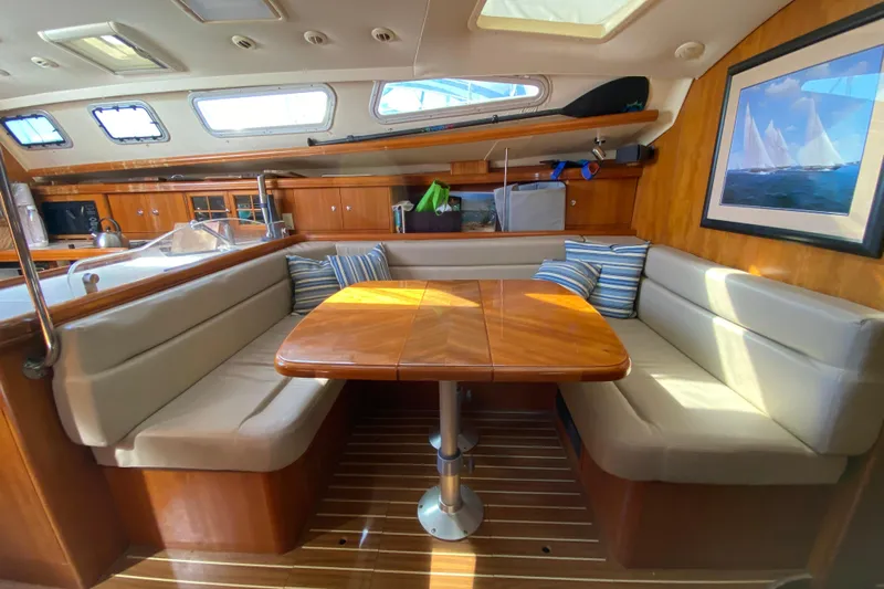 Dolce Vita Yacht Photos Pics Interior of 2004 Hunter 41 AC sailboat with cozy dining area and wooden finishes.