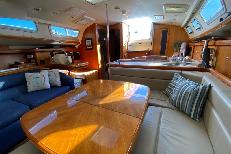 Dolce Vita Yacht Photos Pics Luxurious interior of 2004 Hunter 41 AC sailboat with elegant wood finishes and cozy seating.