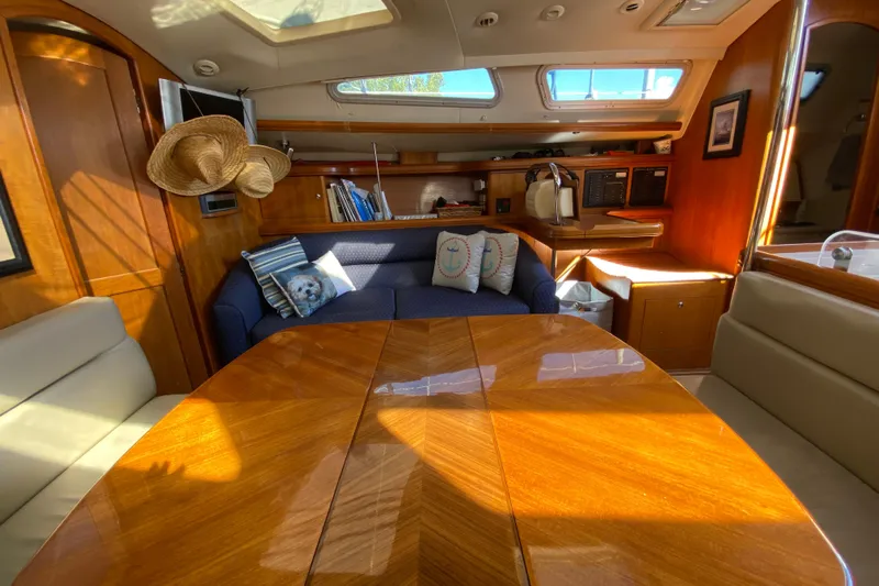 Dolce Vita Yacht Photos Pics Interior of 2004 Hunter 41 AC sailboat with cozy seating and wooden table.