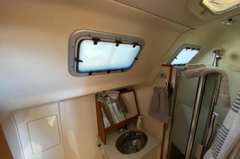 Dolce Vita Yacht Photos Pics Bathroom interior of 2004 Hunter 41 AC sailboat with sink, mirror, and shower.