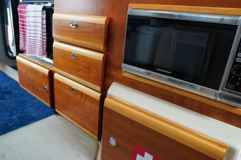 E Ticket Yacht Photos Pics Interior of 2015 Cutwater 30 Command Bridge with wooden cabinetry and built-in microwave.