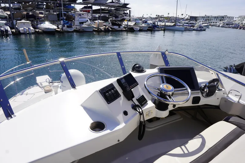 E Ticket Yacht Photos Pics 2015 Cutwater 30 Command Bridge helm with marina view, featuring modern controls and steering.