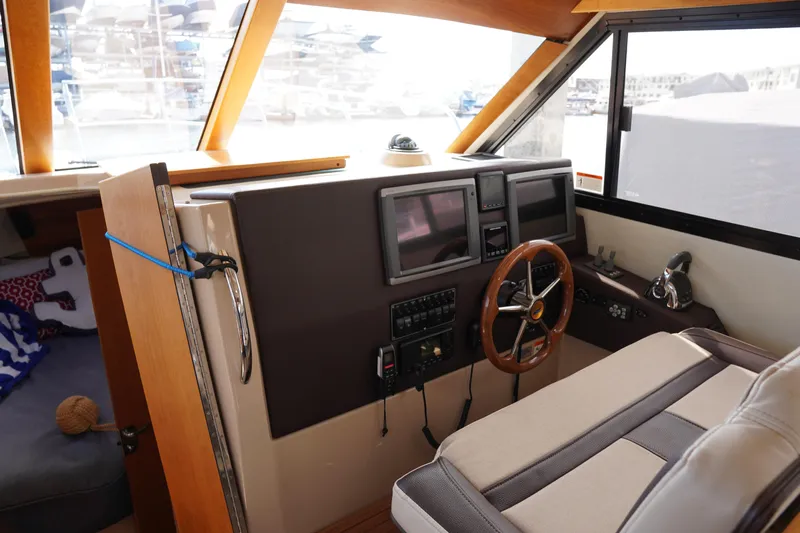 E Ticket Yacht Photos Pics Interior helm of 2015 Cutwater 30 Command Bridge with steering wheel and navigation screens.