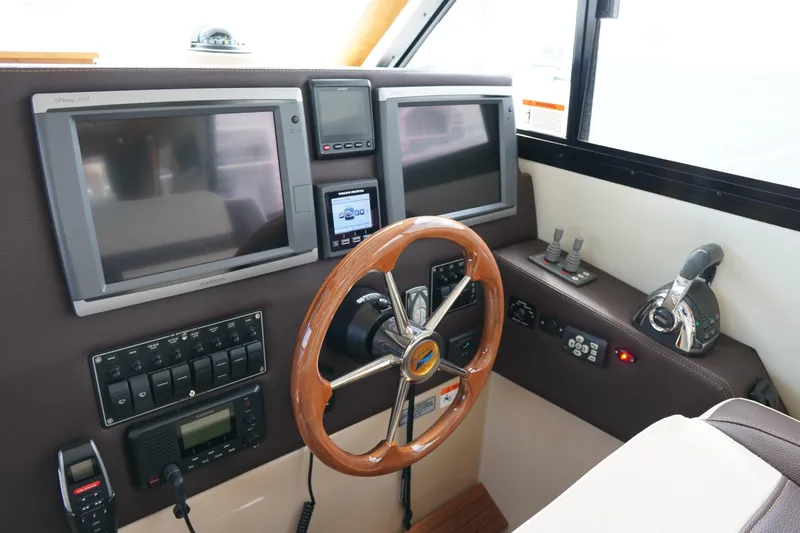 E Ticket Yacht Photos Pics 2015 Cutwater 30 Command Bridge helm with dual screens and wooden steering wheel.