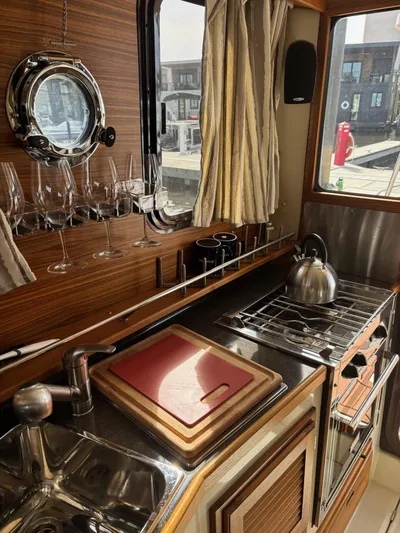  Yacht Photos Pics 2024 Ranger Tugs R31S kitchen interior with sink, stove, and wine glasses.