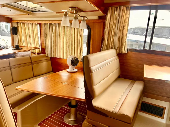  Yacht Photos Pics 2024 Ranger Tugs R31S interior with wood finish, dining area, and beige seating.