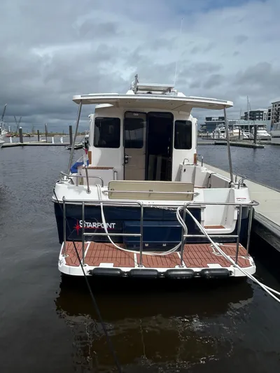  Yacht Photos Pics 2024 Ranger Tugs R31S docked at a marina under cloudy skies.