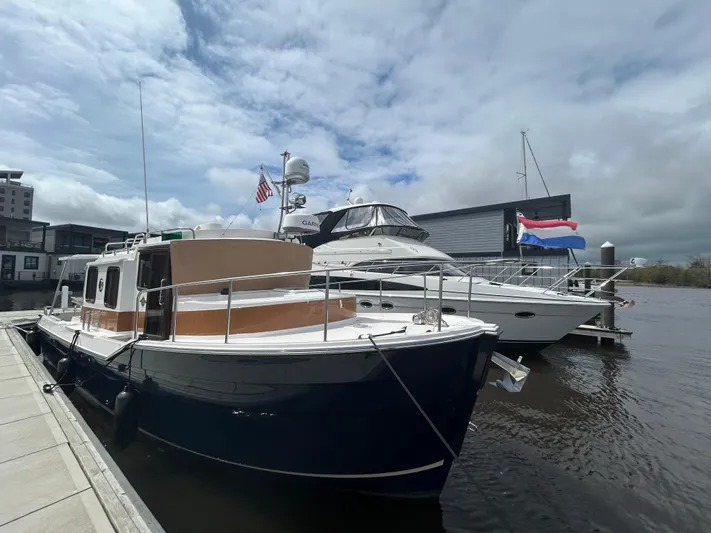  Yacht Photos Pics 2024 Ranger Tugs R31S docked at marina under cloudy sky.
