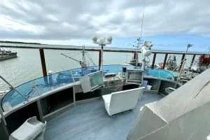 Western Shore Yacht Photos Pics 1989 Custom Expedition boat deck with seating, overlooking a calm harbor under cloudy skies.