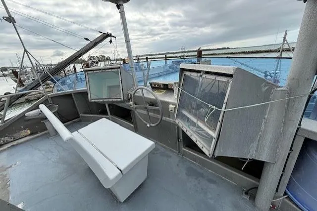 Western Shore Yacht Photos Pics 1989 Custom Expedition boat deck with steering wheel, bench, and overcast sky.