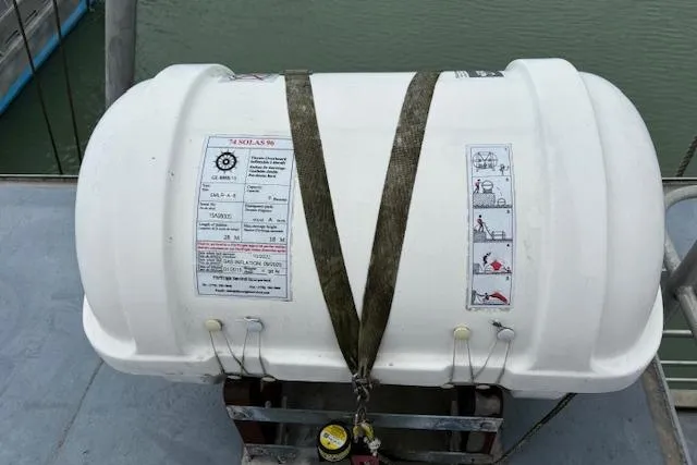 Western Shore Yacht Photos Pics Lifeboat container secured on a ship deck, featuring safety instructions and labels.