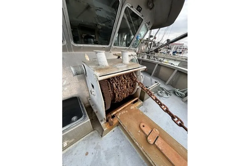 Western Shore Yacht Photos Pics Rusty anchor winch on 1989 Custom Expedition boat deck, with visible chain and windows.
