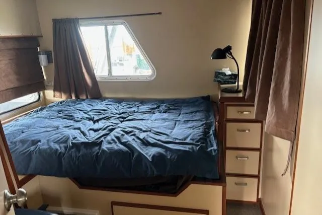 Western Shore Yacht Photos Pics Cozy interior of a 1989 Custom Expedition RV with bed, window, and storage drawers.