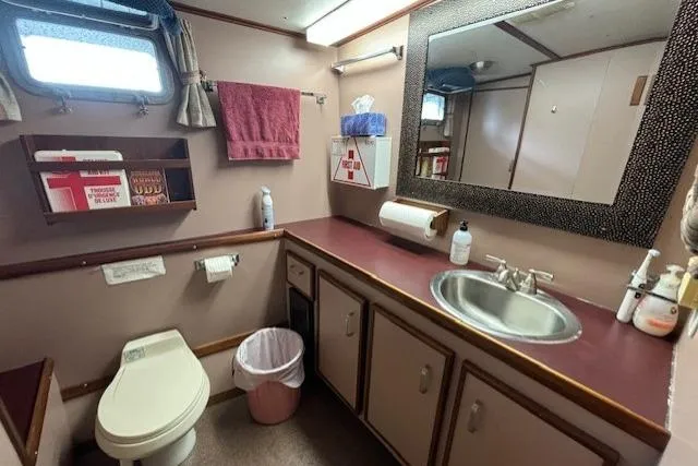 Western Shore Yacht Photos Pics Bathroom in a 1989 Custom Expedition vehicle with sink, toilet, and storage cabinets.