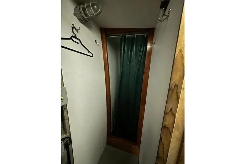 Western Shore Yacht Photos Pics Narrow shower space in a 1989 Custom Expedition vehicle with hooks and green curtain.