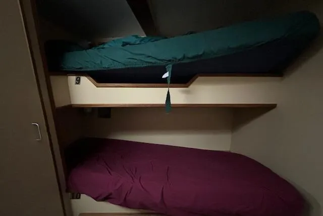 Western Shore Yacht Photos Pics Bunk beds inside a 1989 Custom Expedition vehicle, featuring green and maroon bedding.