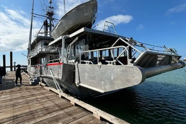 Western Shore Yacht Photos Pics 1989 Custom Expedition boat docked, featuring sturdy design and upper deck lifeboat.