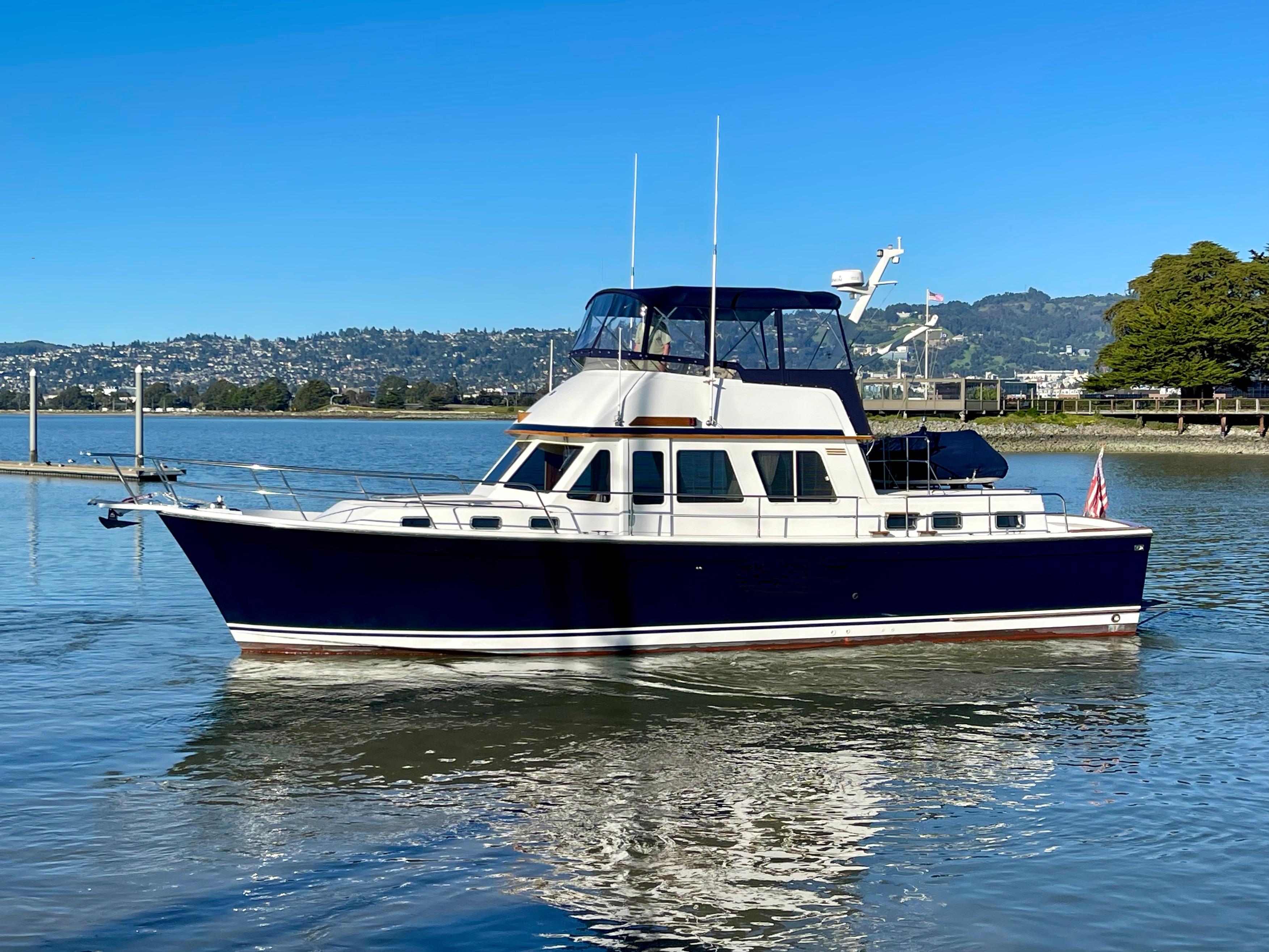 1997 Sabre Cockpit Motor Yacht on calm water, clear sky background.