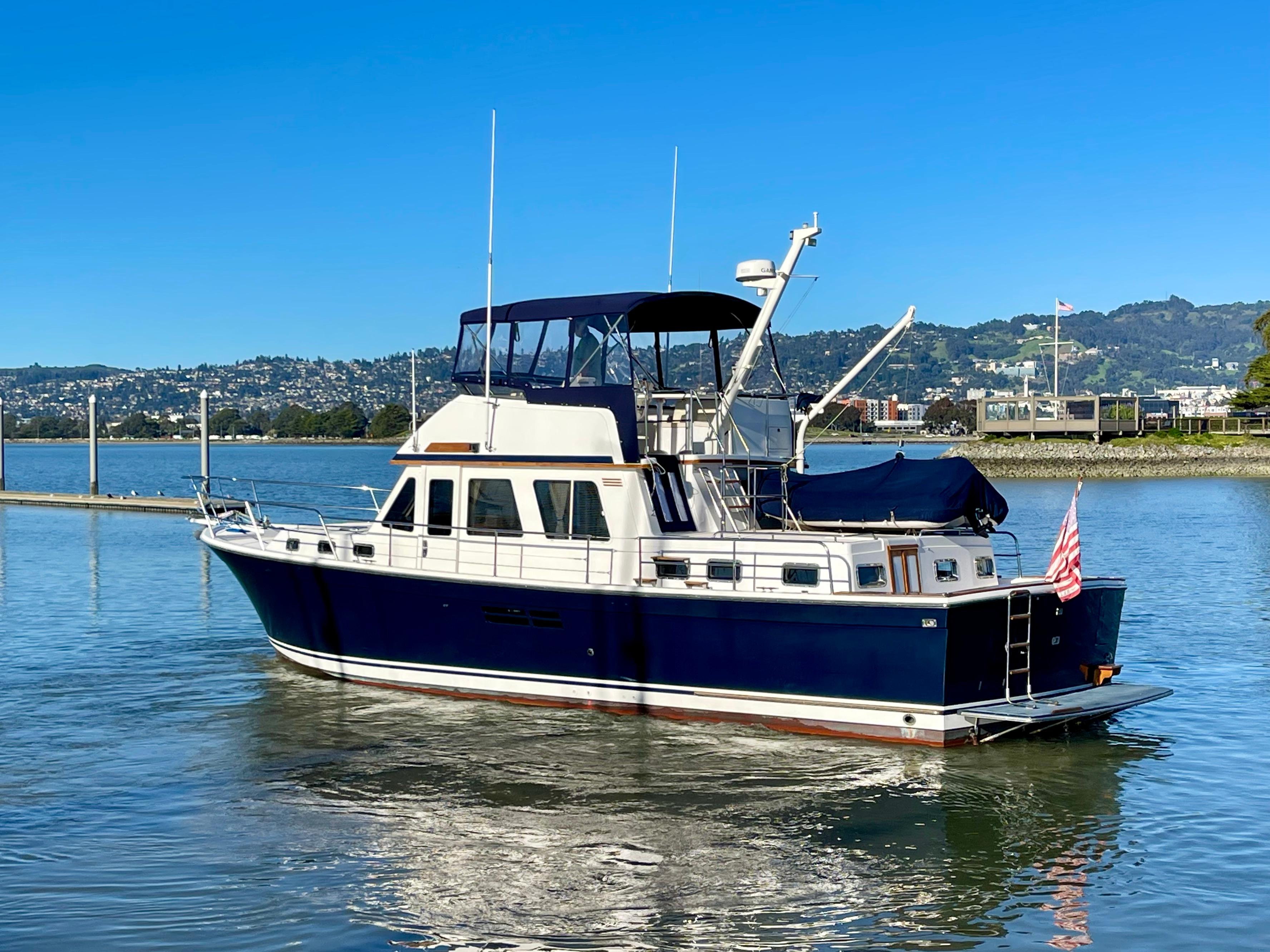 1997 Sabre Cockpit Motor Yacht on calm water with scenic background.