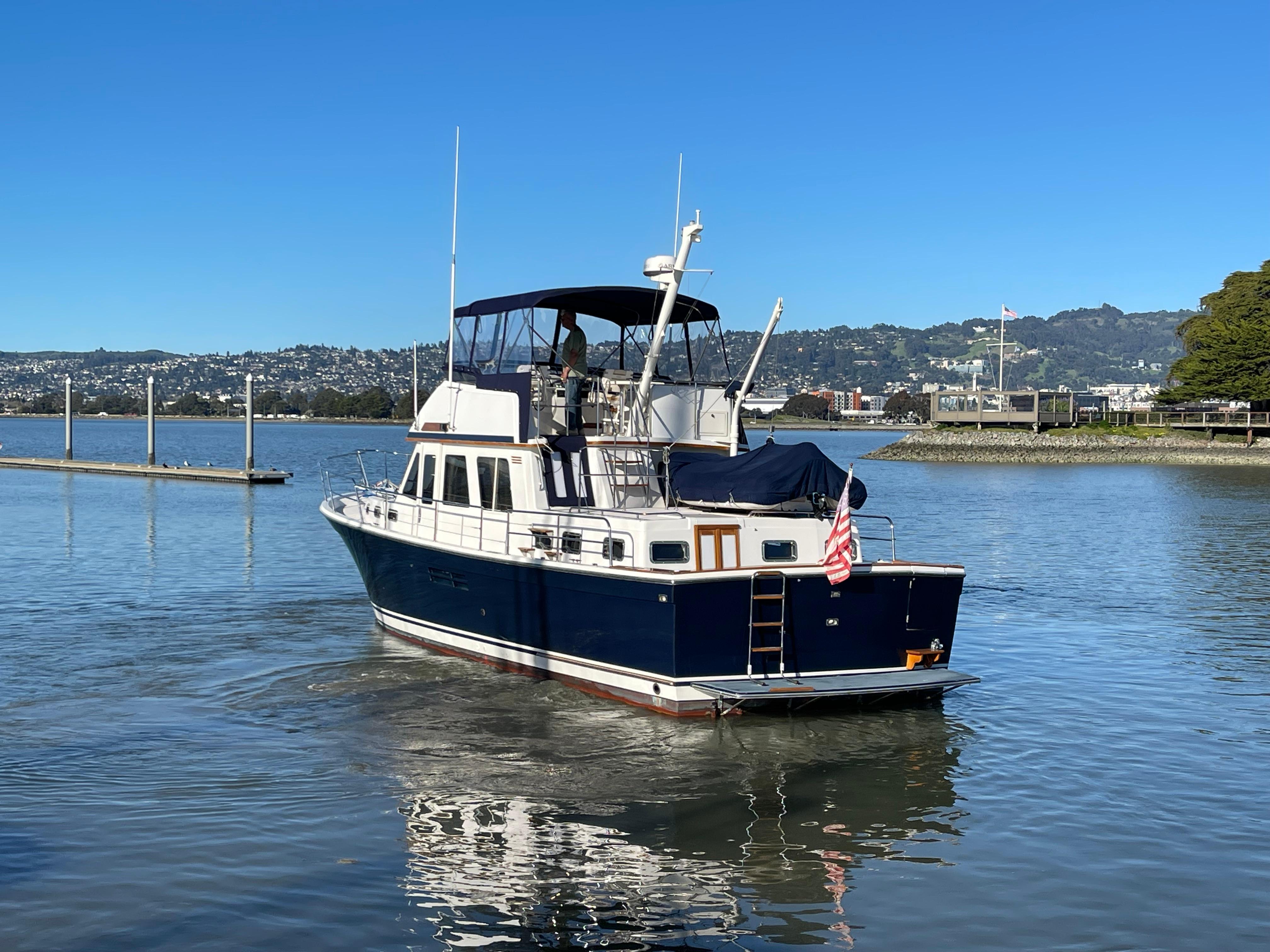 1997 Sabre Cockpit Motor Yacht on calm water, clear sky, scenic background.