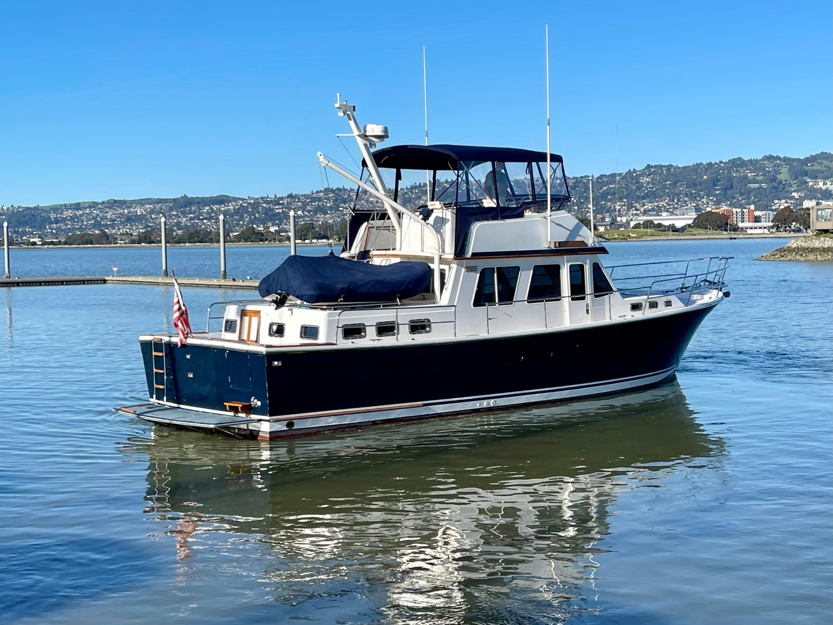 1997 Sabre Cockpit Motor Yacht on calm water with scenic background.