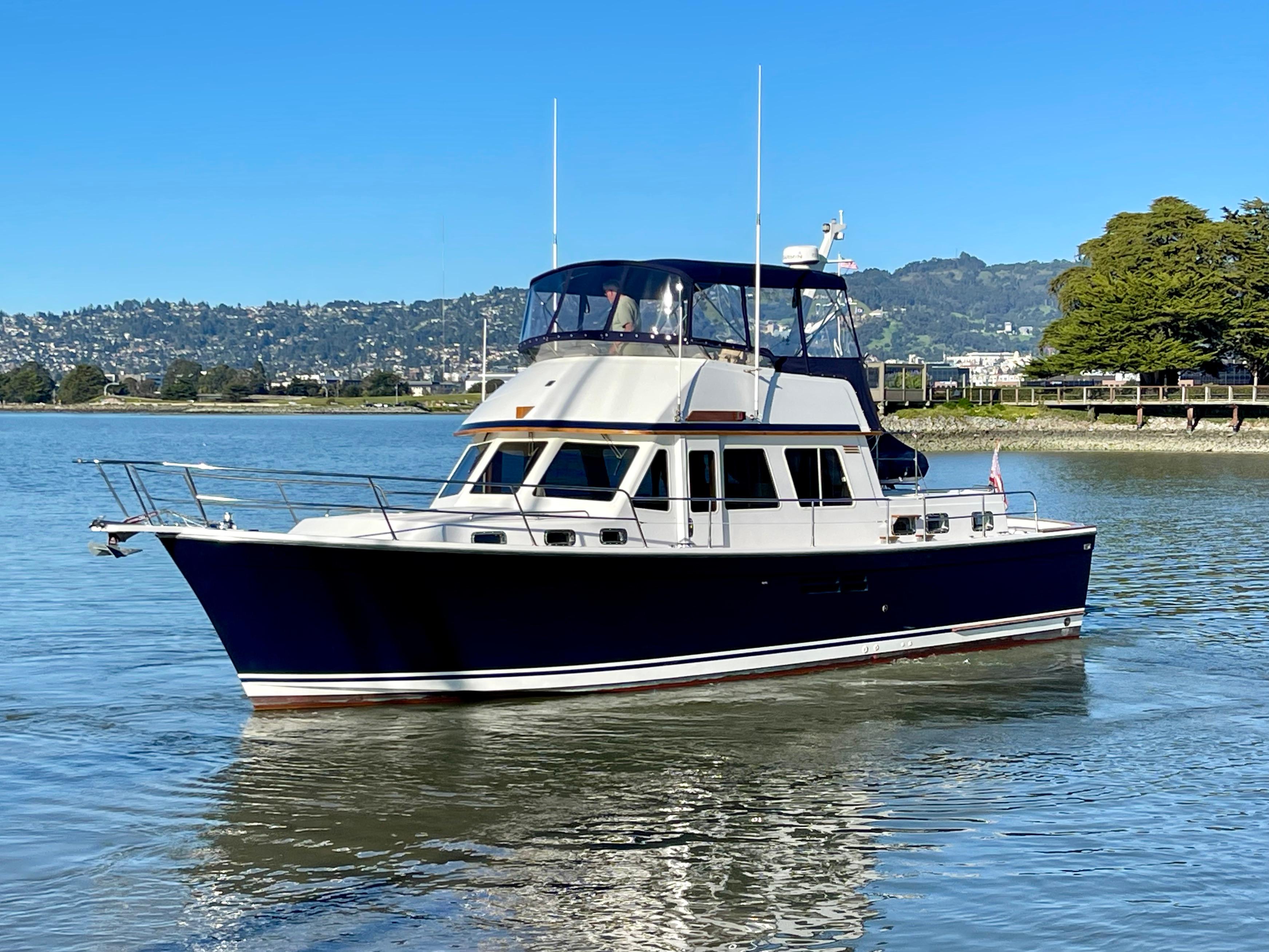 1997 Sabre Cockpit Motor Yacht on calm water with scenic background.
