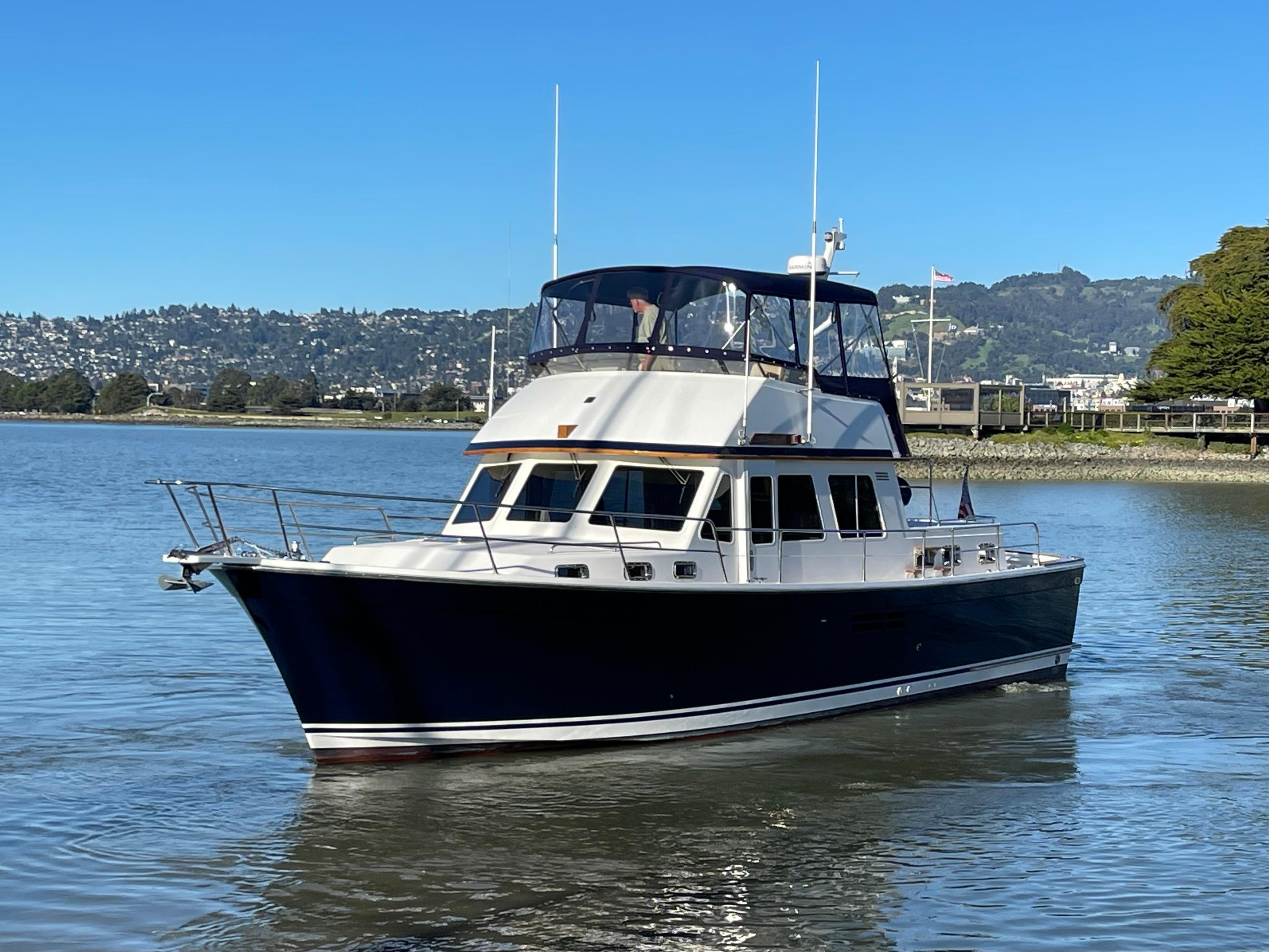 1997 Sabre Cockpit Motor Yacht on calm water, clear sky, scenic background.