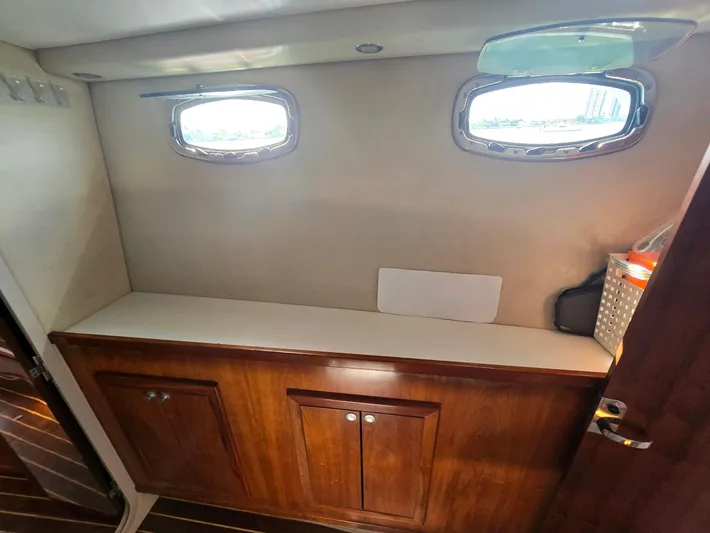 Alacrity Yacht Photos Pics Interior of 2009 Fusion 40 boat with wooden cabinets and porthole windows.