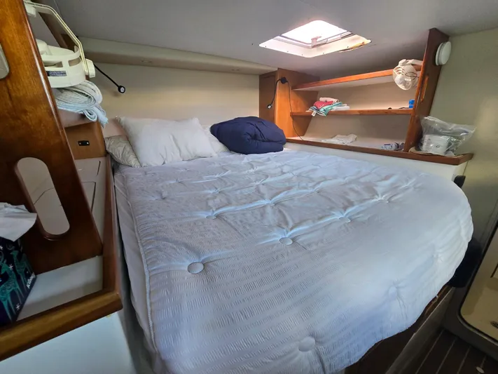Alacrity Yacht Photos Pics Cozy cabin bedroom in 2009 Fusion 40 yacht with skylight and wooden shelves.