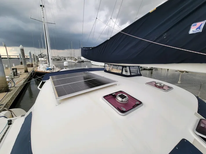 Alacrity Yacht Photos Pics 2009 Fusion 40 sailboat with solar panel, docked at marina under cloudy sky.