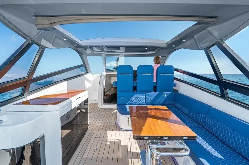  Yacht Photos Pics Interior of 2023 Bavaria Vida 33 yacht with blue seating and wooden table.