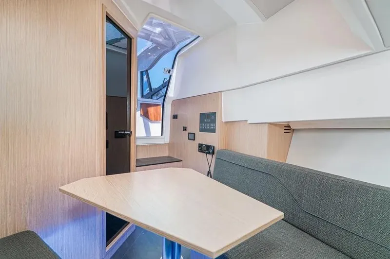  Yacht Photos Pics 2023 Bavaria Vida 33 interior with modern seating and wooden table.