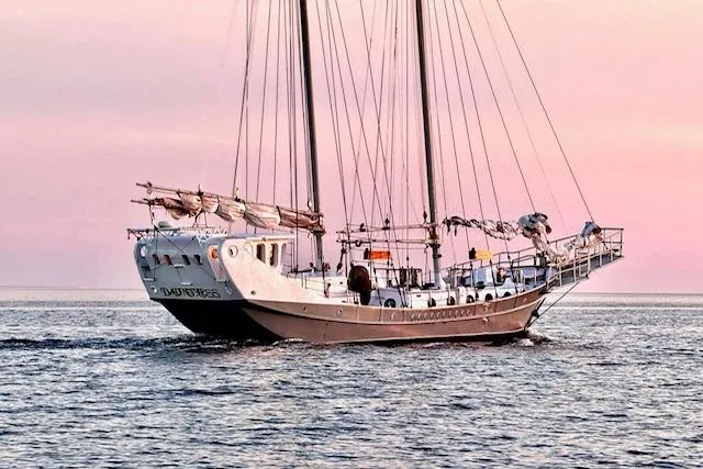 Dauntless Yacht Photos Pics Custom 1989 Schooner Live aboard sailing at sunset on calm waters.