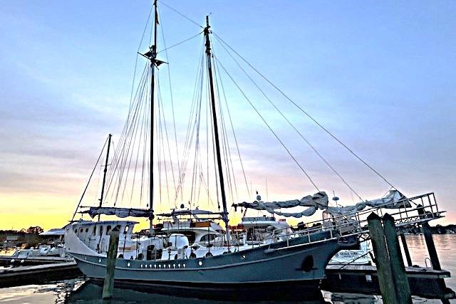 Custom 1989 Schooner Live aboard docked at sunset, showcasing elegant masts and serene waters.