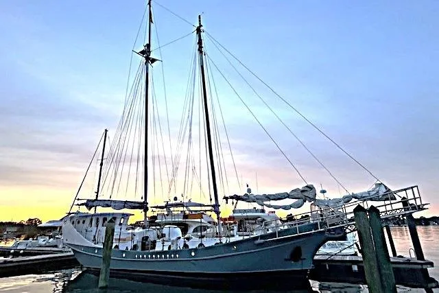 Custom 1989 Schooner Live aboard docked at sunset, showcasing elegant masts and serene waters.