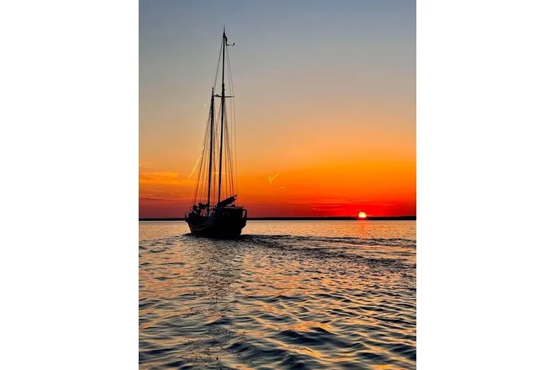Dauntless Yacht Photos Pics Schooner sailing at sunset, 1989 Custom Live aboard, tranquil ocean scene.