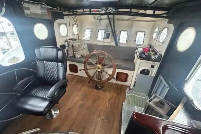 Dauntless Yacht Photos Pics Interior of 1989 Custom Schooner Live aboard with wooden wheel and leather chair.